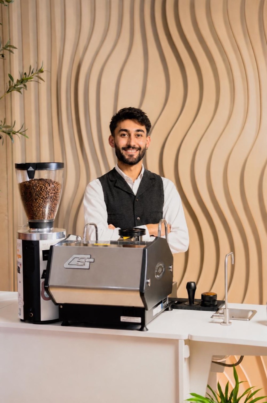 Huseyin standing behind the BrewJoy espresso bar