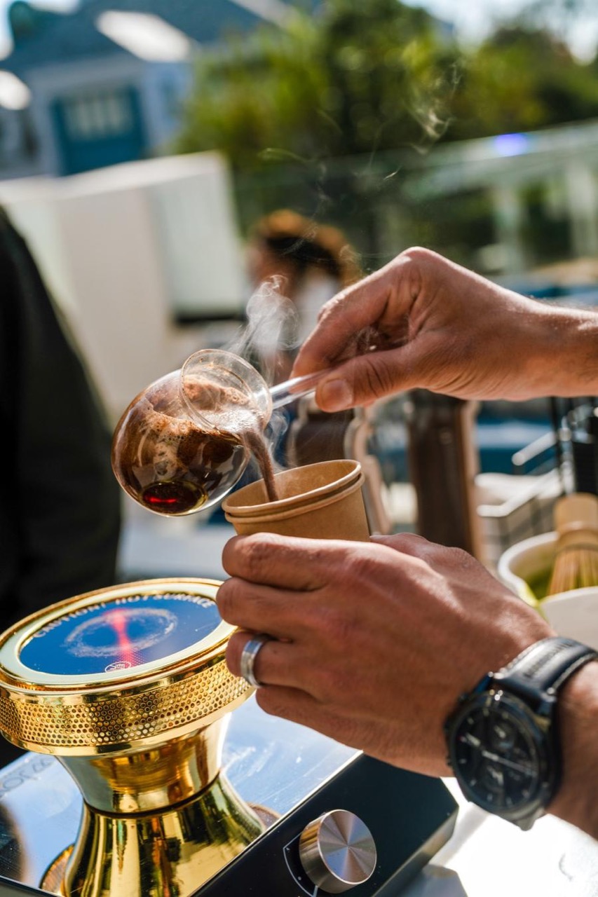 Traditional copper cezve Turkish coffee prepared over hot sand at a Southern California event